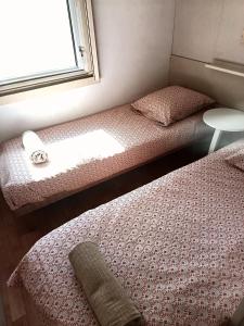 two beds in a small room with a window at Escale en Provence in Carqueiranne