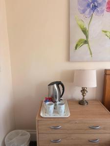 a table with a tea kettle and two cups on it at The Avenue GuestHouse in Newcastle upon Tyne +21 photos