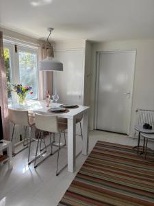 a white kitchen with a white table and chairs at Blossom in Bergen +16 photos