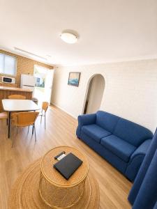 a living room with a blue couch and a table at Ocean View Villas in Geraldton