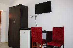 a room with a table and two chairs and a tv at ANORA Mare Suites in Orikum