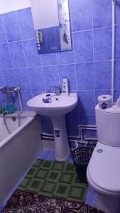 a bathroom with a sink and a toilet and a tub at UYUT INN apartment in Samarkand