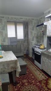 a kitchen with a stove and a table and a table and a table sidx sidx at UYUT INN apartment in Samarkand