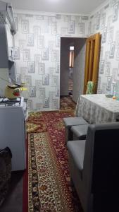 a room with a table and couches in a room at UYUT INN apartment in Samarkand