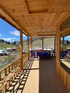 a wooden deck with blue chairs and tables on it at Peak Paradise Resort in Taobat