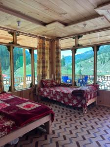 a bedroom with two beds and a large window at Peak Paradise Resort in Taobat