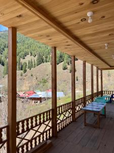 a wooden porch with a view of the mountains at Peak Paradise Resort in Taobat