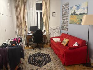 a living room with a red couch and a desk at partie jasmin in Brussels