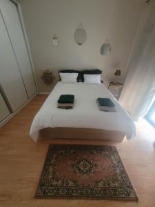 a bedroom with a large white bed with a rug at Gite espumante in Mamarrosa +11 photos