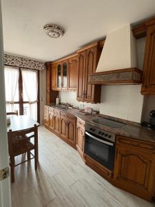 a kitchen with wooden cabinets and a stove top oven at Saron Centro in Sarón