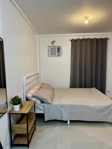 a small bedroom with a bed and a table at Sebastians CRIB D in Dasmariñas