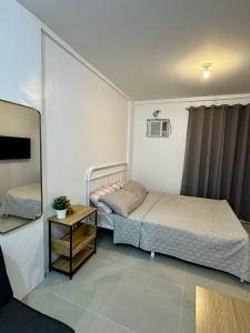 a small bedroom with a bed and a table at Sebastians CRIB D in Dasmariñas +7 photos
