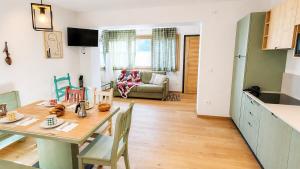 a kitchen and living room with a table and chairs at Verde Betulla, Free Park and Ski room in Camporosso in Valcanale +1 photo