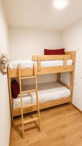 two bunk beds in a room with wooden floors at Verde Betulla, Free Park and Ski room in Camporosso in Valcanale