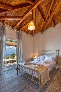 a bedroom with a bed and a large window at Eltheo Villas in Agios Nikitas