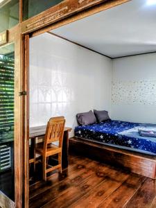 a bedroom with a bed and a wooden chair at Lake view house in Ko Phangan