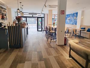 a restaurant with wooden floors and tables and chairs at Hotel OCTOPUS in Can Picafort