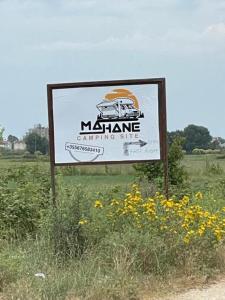 a sign in the middle of a field with flowers at Camping Ohel in Mullini i Danit