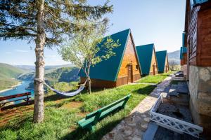a row of cottages on a hill with a hammock at Rural Resort Tron Gold in Plužine