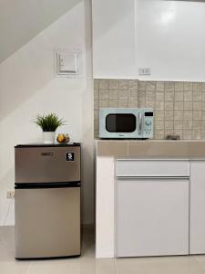 a kitchen with a microwave on top of a counter at Sebastians CRIB D in Dasmariñas