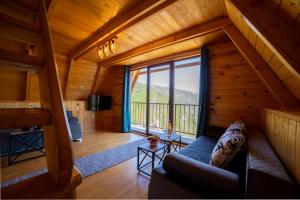 a living room with a couch and a large window at Rural Resort Tron Gold in Plužine
