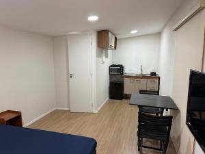 a small room with a table and a kitchen at Casa de campo em meio a natureza in Araras Petropolis