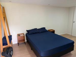 a bedroom with a blue bed and a ladder at Casa de campo em meio a natureza in Araras Petropolis