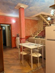 ein Esszimmer mit Tisch und Stühlen und eine Treppe in der Unterkunft Clio 21 in Marina di Massa