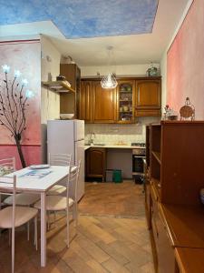 eine Küche mit einem Tisch und einem weißen Kühlschrank in der Unterkunft Clio 21 in Marina di Massa