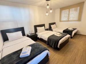 a hotel room with two beds and two trunks at Alto Faqra in Brummānā +6 photos