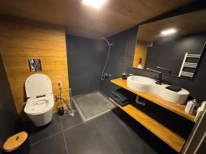 a bathroom with a white toilet and a sink at Alto Faqra in Brummānā