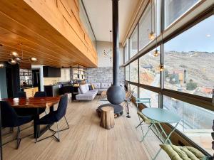 a living room with a dining table and a large window at Alto Faqra in Brummānā