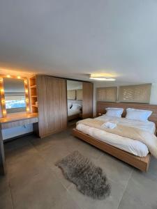 a large bedroom with a large bed and a rug at Alto Faqra in Brummānā