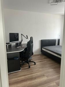 a bedroom with a desk with a computer and a bed at Aaberg Lounge in Waldshut-Tiengen
