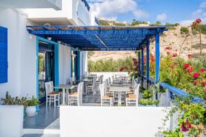 a patio with tables and chairs and flowers at Blue Sea Hotel in Amoopi