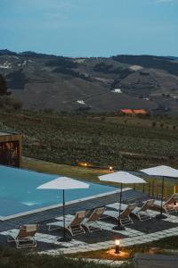 a group of chairs and umbrellas next to a pool at Five Sabrosa Senses in Sabrosa