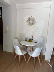 a dining room with a table and white chairs at Apartman Biljana in Rafailovici