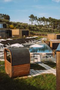 a pool with chairs and umbrellas next to at Five Sabrosa Senses in Sabrosa
