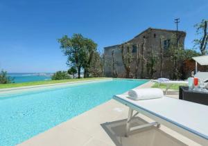 a swimming pool with a table and a building at Villa Krizia - Ancona, meravigliosa villa con piscina vista mare in Ancona