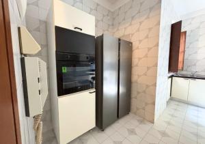 a stainless steel refrigerator in a small kitchen at Villa Krizia - Ancona, meravigliosa villa con piscina vista mare in Ancona