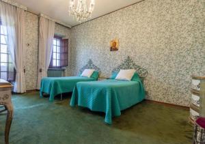 a bedroom with two beds and a chandelier at Villa Krizia - Ancona, meravigliosa villa con piscina vista mare in Ancona +23 photos