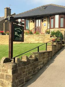 a sign in front of a house at Meadow Lodge in Tideswell