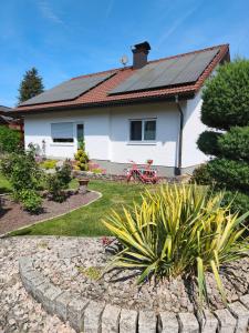 a house with a solar roof and a garden at Ferienwohnung Bigi in Efringen-Kirchen