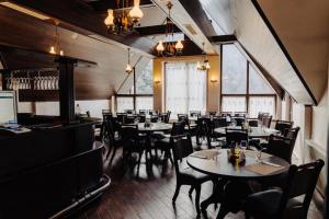 a dining room with tables and chairs and windows at Albert Mountain Retreat & SPA in Lepşa