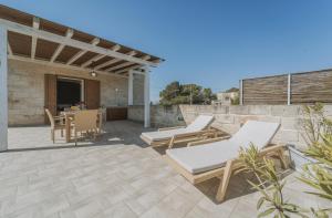a patio with chairs and a table on a patio at Cave Garden rooms in Favignana