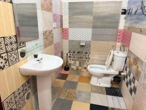 a bathroom with a toilet and a sink at Green House Holiday Villa in Trincomalee