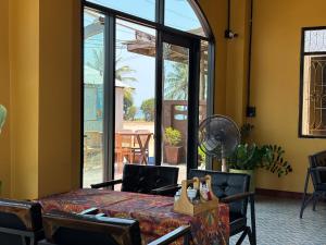 a dining room with a table and a large window at Phoenix Room in Ban Tha Samet (1)