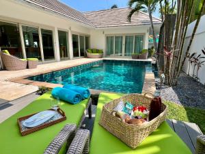 a table with a basket of food next to a swimming pool at Baan Tai Tara 4, Private Pool Villa by Ban Tai Beach in Ban Tai