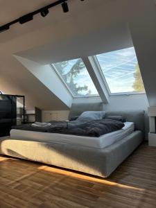 a bedroom with a bed with a large window at Modern Attic Loft in Weisenheim am Sand +20 photos