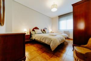 a bedroom with a bed and a chair in it at Casa Raíces de PO in Lapoblación +27 photos